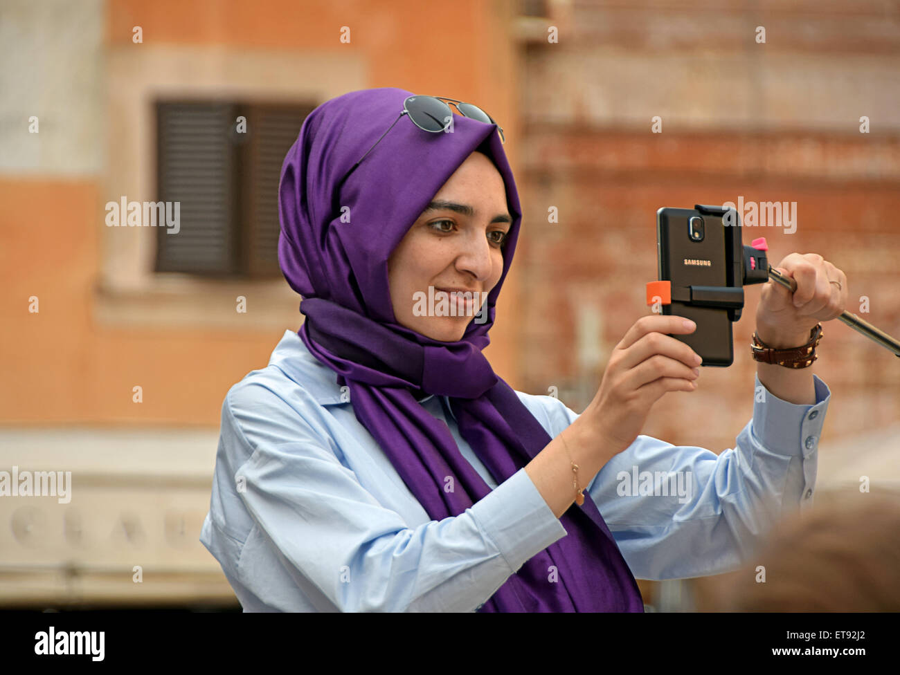 A Muslim woman wearing a purple hijab takes a selfie near the Pantheon in Rome, Italy Stock Photo