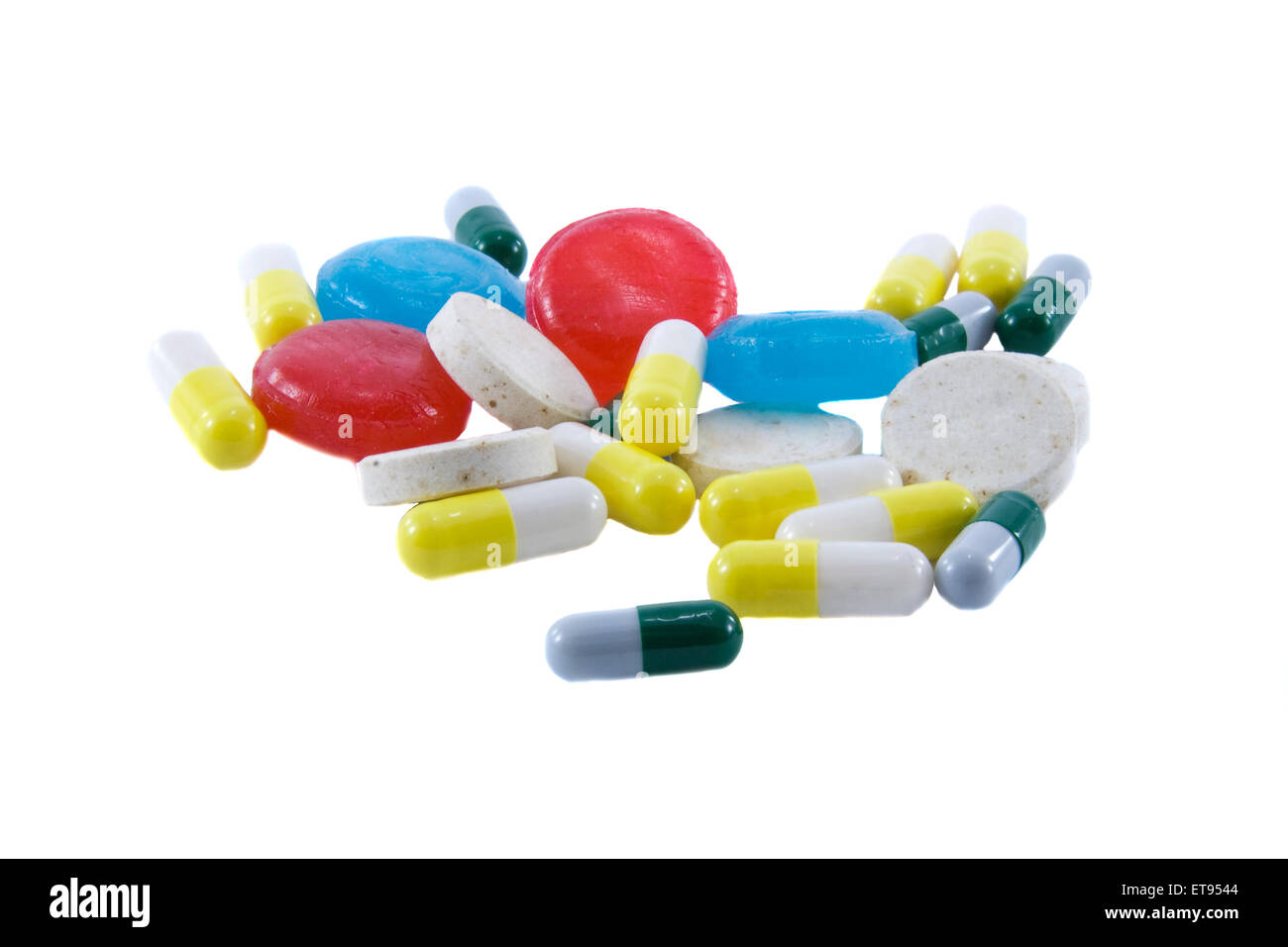Many different color tablets and pills isolated over white backg Stock Photo
