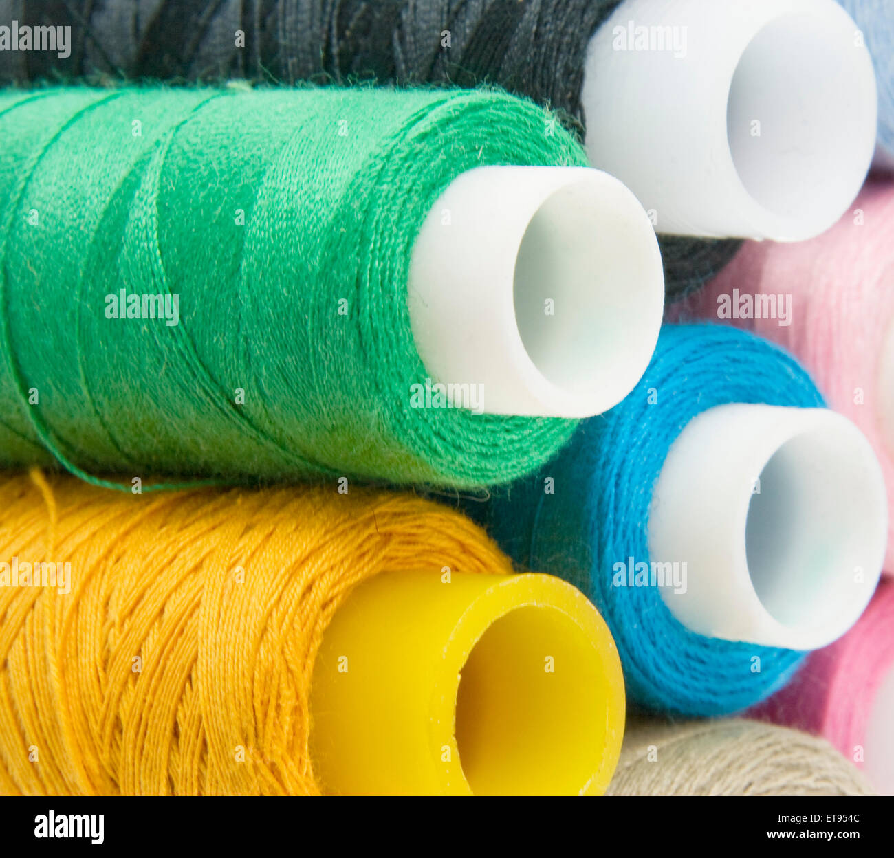 Many colorful different threads over background Stock Photo - Alamy