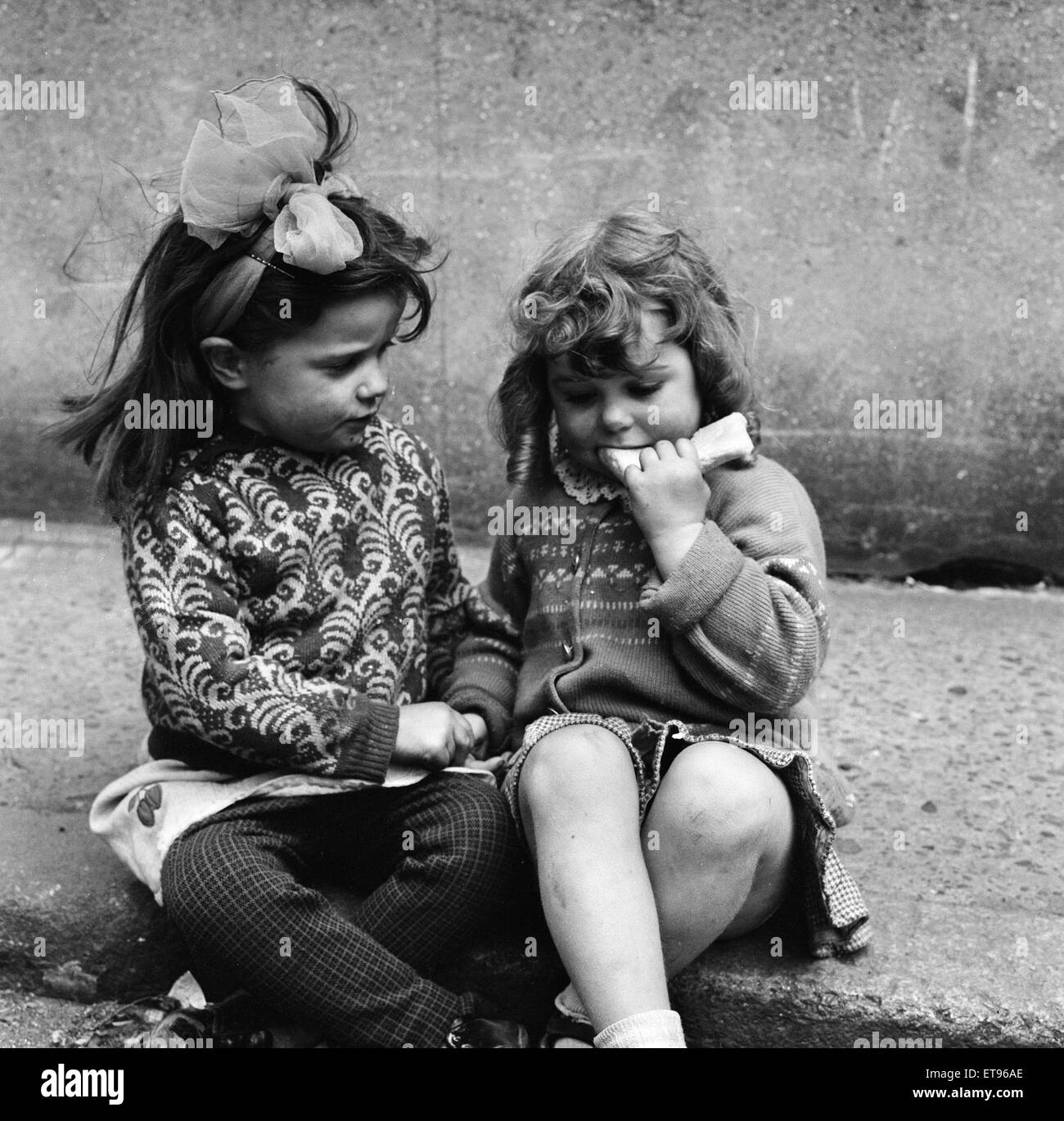 Slums, Benburb street area of Dublin, Republic of Ireland, 11th May 1968. Dublin slums controlled by the municipal authority, the Dublin Corporation, which has had to ignore standards of hygiene and sanitation. Pictured. two young girls sit on pavement Ke Stock Photo