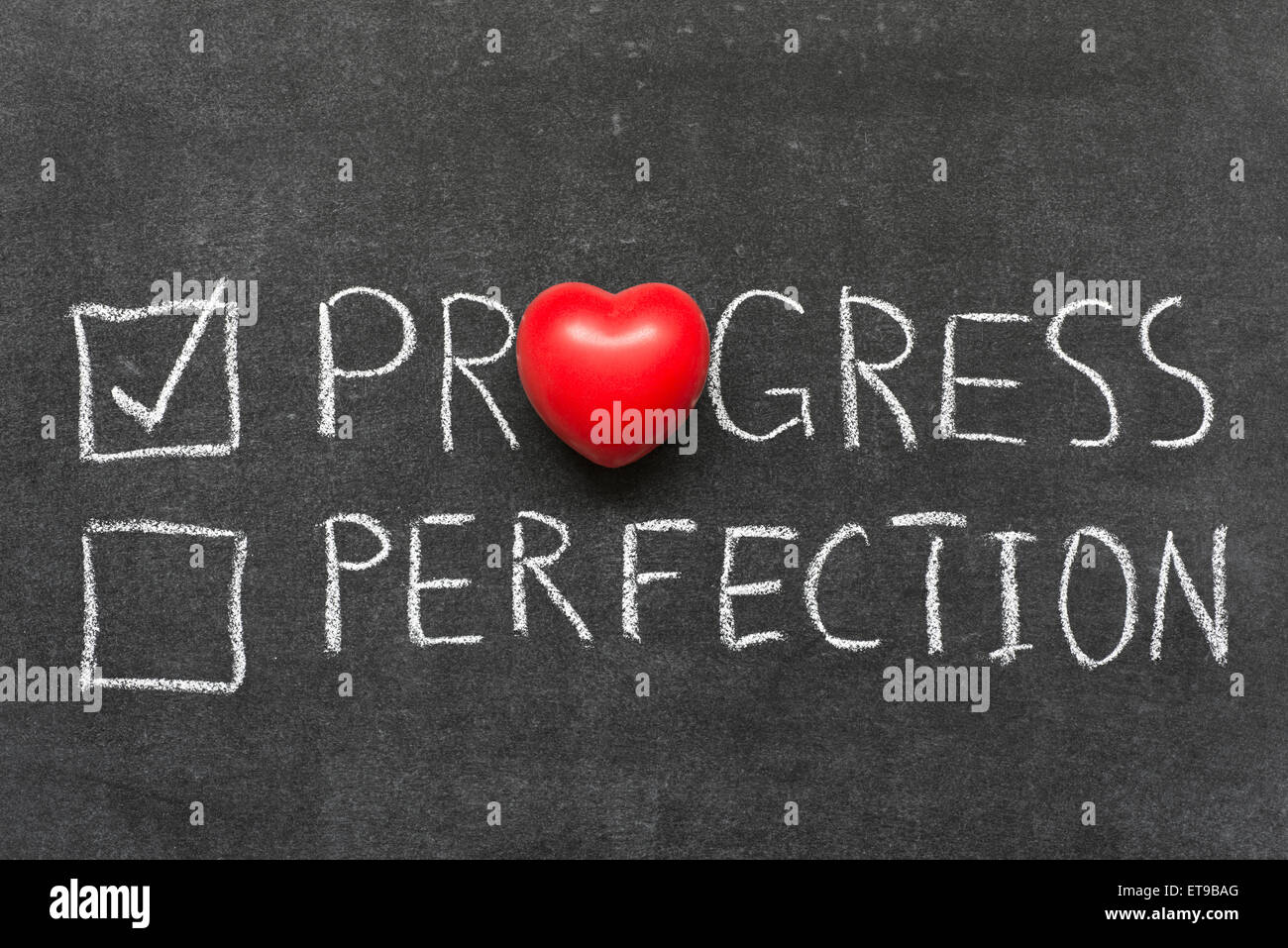 choose progress not perfection concept handwritten on blackboard with heart symbol instead of O Stock Photo