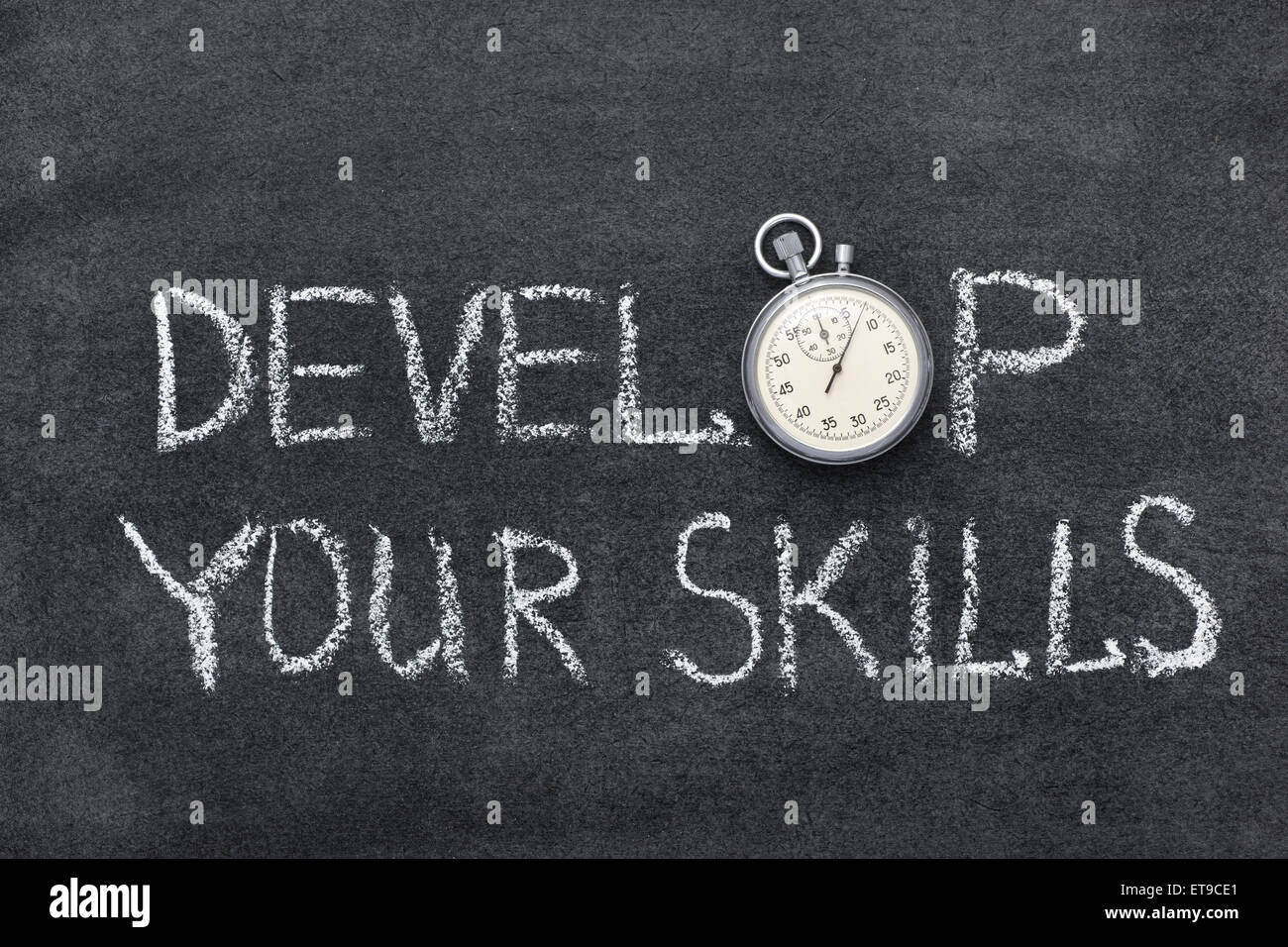 develop your skills phrase handwritten on chalkboard with vintage precise stopwatch used instead of O Stock Photo