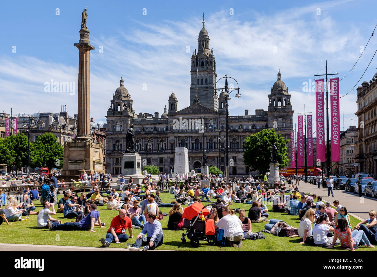 Glasgow, Scotland, UK. 12th June, 2015. At lunch time many people from the city centre offices, shoppers and tourists are enjoying their break by sunbathing in the open areas of George Square, in Glasgow city centre where with sunny skies, the temperature soared to 24C Credit:  Findlay/Alamy Live News Stock Photo