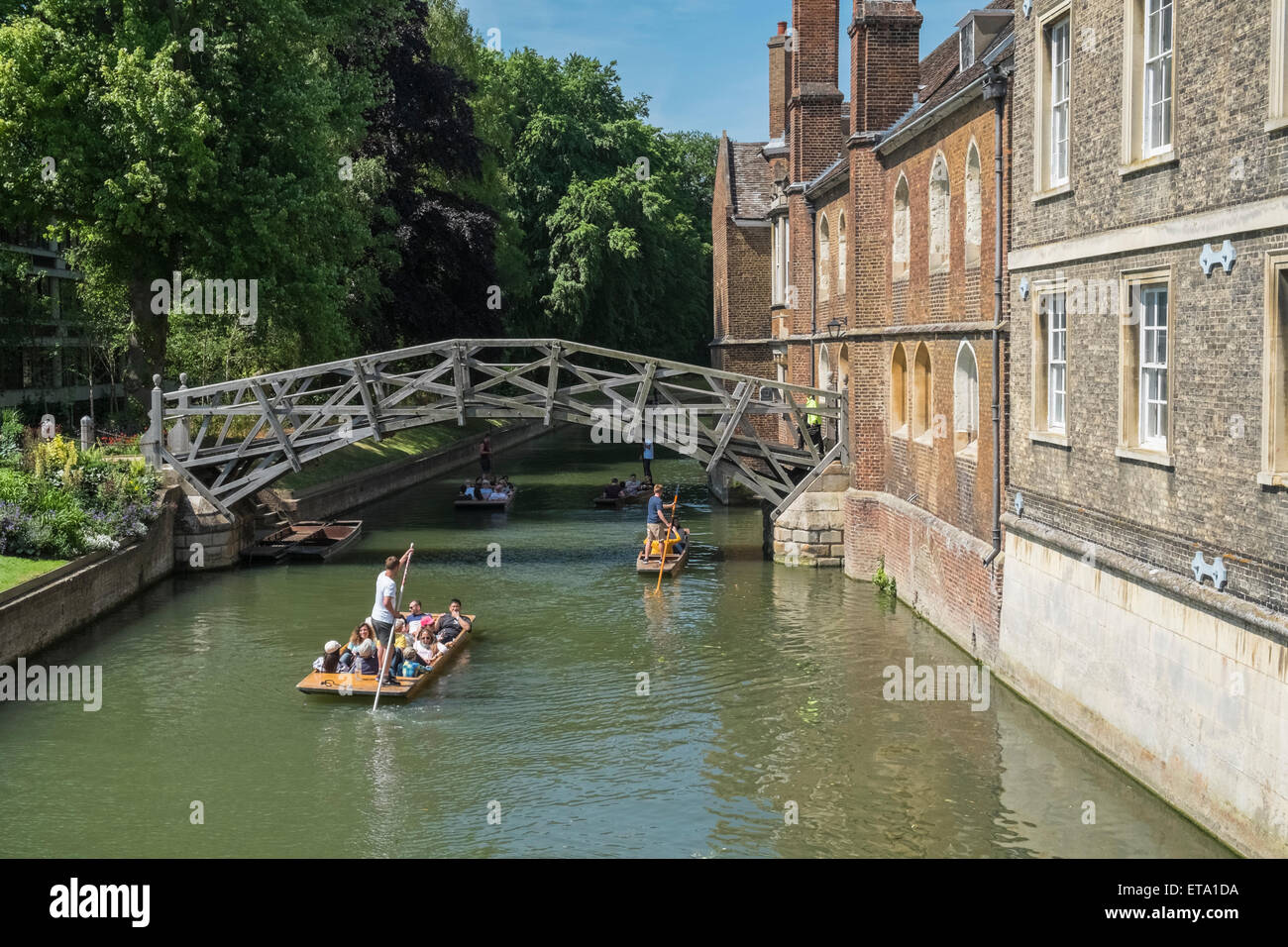 Punting on River Cam, near Mathematical Bridge, Cambridge, UK. The bridge connects 2 parts of Queens College. Stock Photo