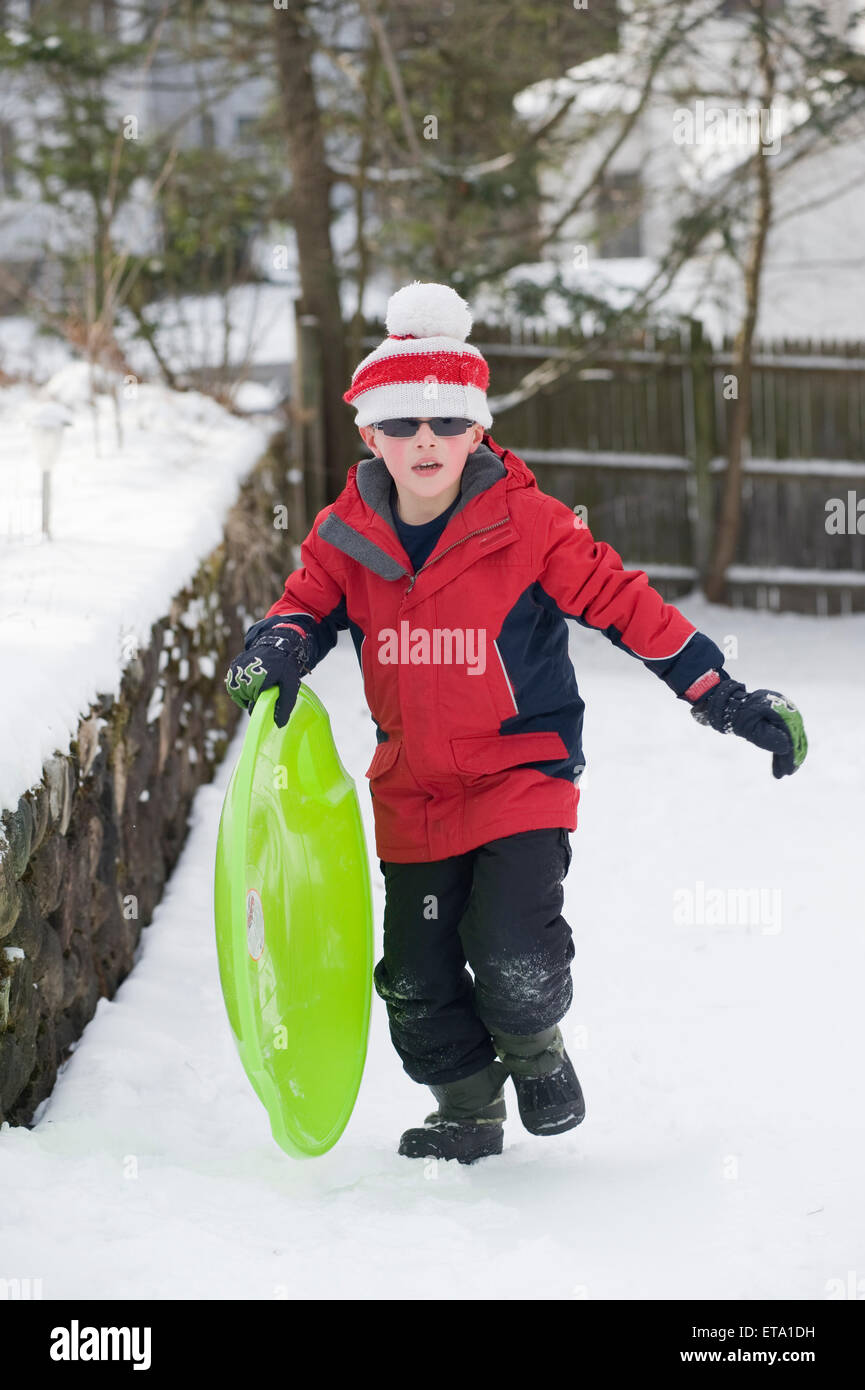 eight year old sledding in the snow Stock Photo