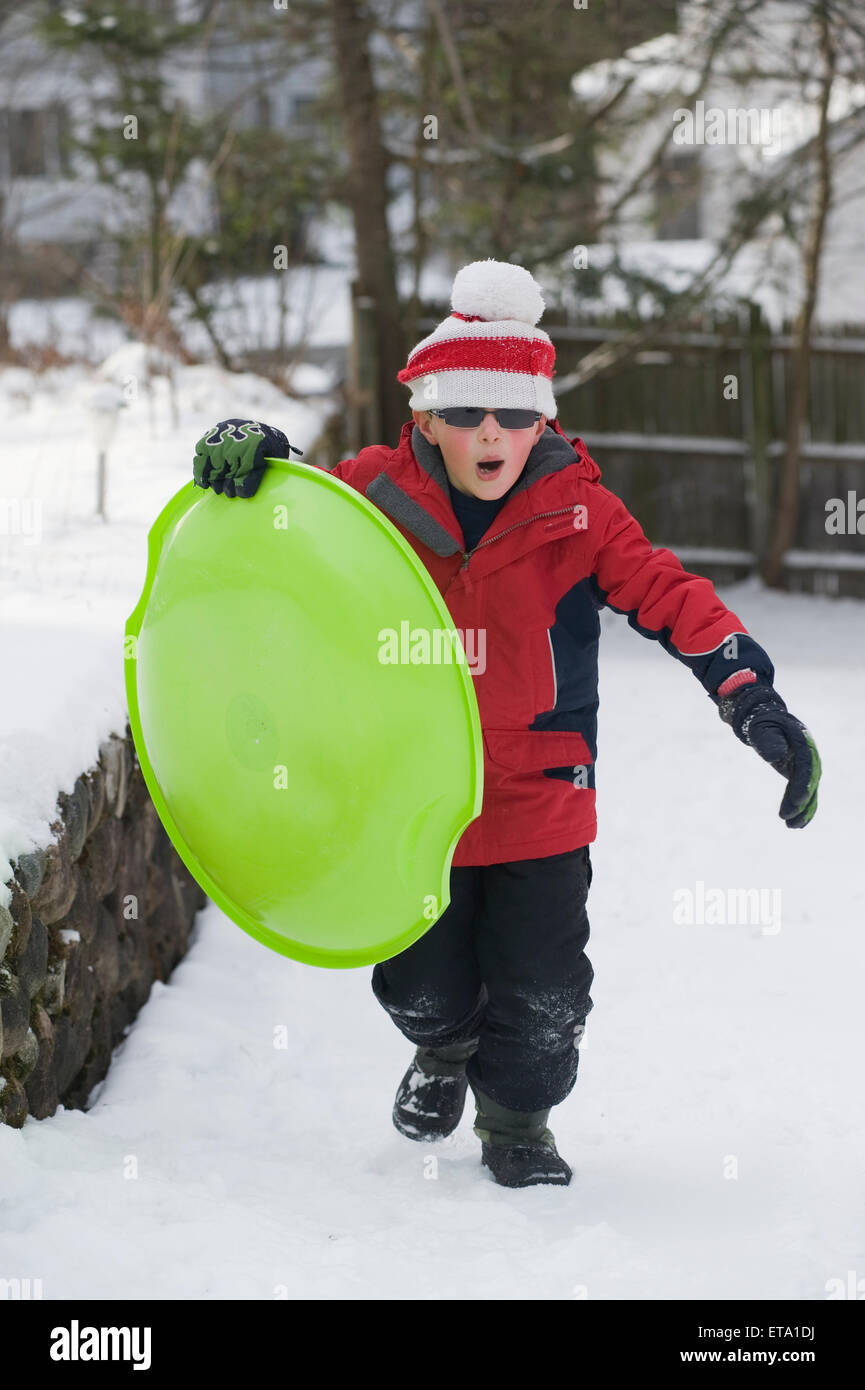 Eight year old sledding in the snow Stock Photo