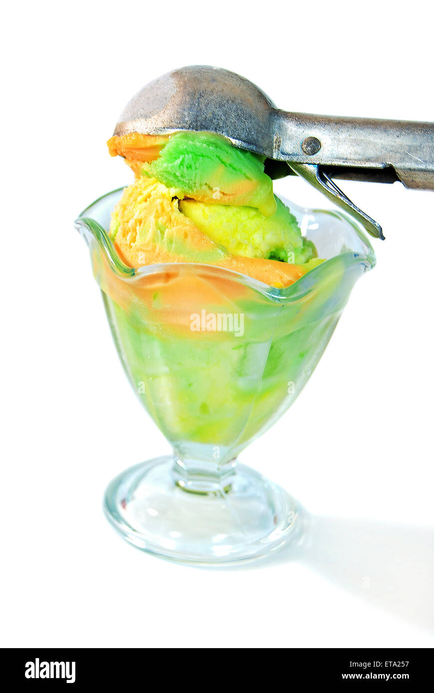 Colorful sherbet in sundae glass with old ice cream scoop isolated on white background. Stock Photo