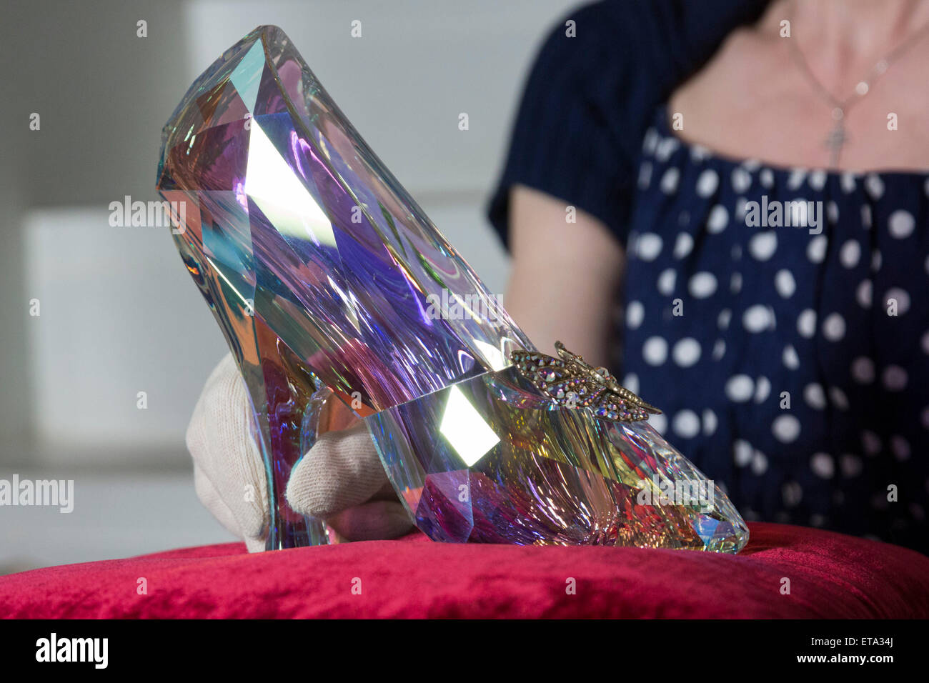 Curator Helen Persson holds Disney's Cinderella slipper ahead of the new  V&A summer fashion exhibition "Shoes: Pleasure and Pain" which focuses on  the transformative power of shoes. The slipper was created by