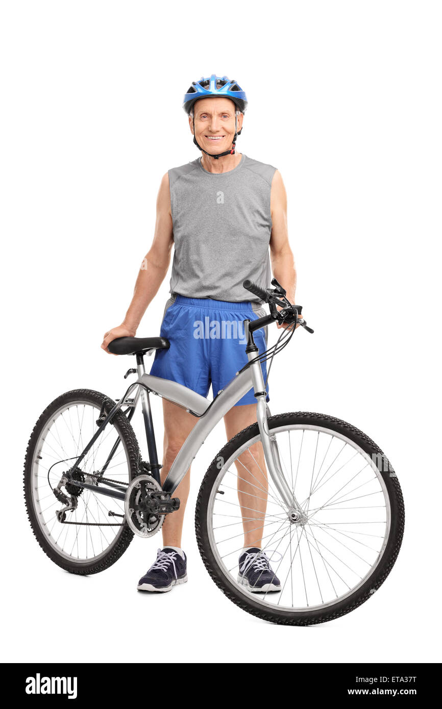 Full length portrait of a senior biker standing behind a bicycle and smiling isolated on white background Stock Photo
