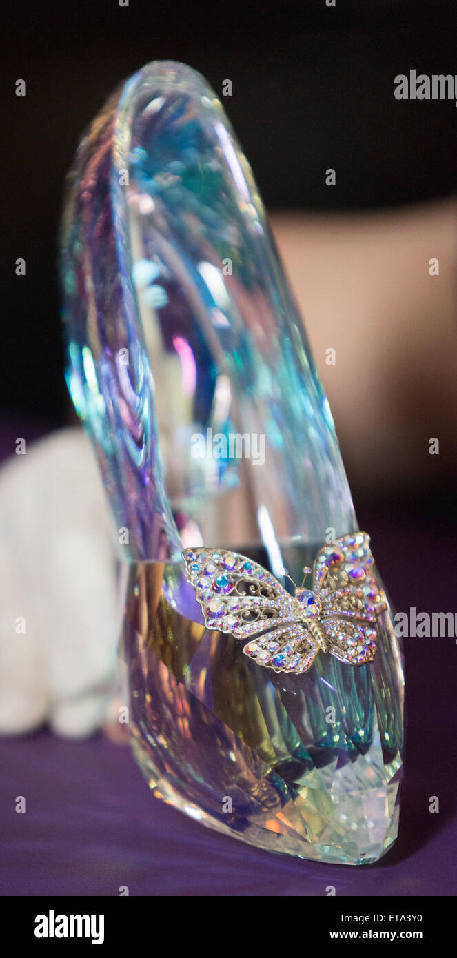 Curator Helen Persson holds Disney's Cinderella slipper ahead of the new V&A summer fashion exhibition "Shoes: Pleasure and Pain" which focuses on the transformative power of shoes. The slipper was created by Swarovski under the direction of Academy Award-winning costume designer Sandy Powell. It was hewn from solid Swarovski crystal and features 221 facets in a light-reflecting Crystal Blue Aurora Borealis coating. The exhibition Shoes: Pleasure and Pain opens to the public on 13 June 2015 and runs to 31 January 2016. Stock Photo