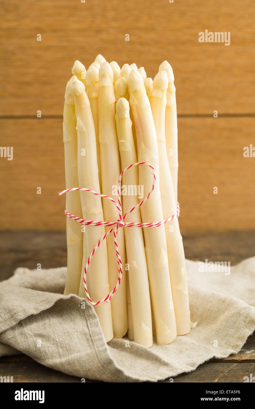 Bunch of fresh white asparagus on wooden table with linen cloth Stock Photo