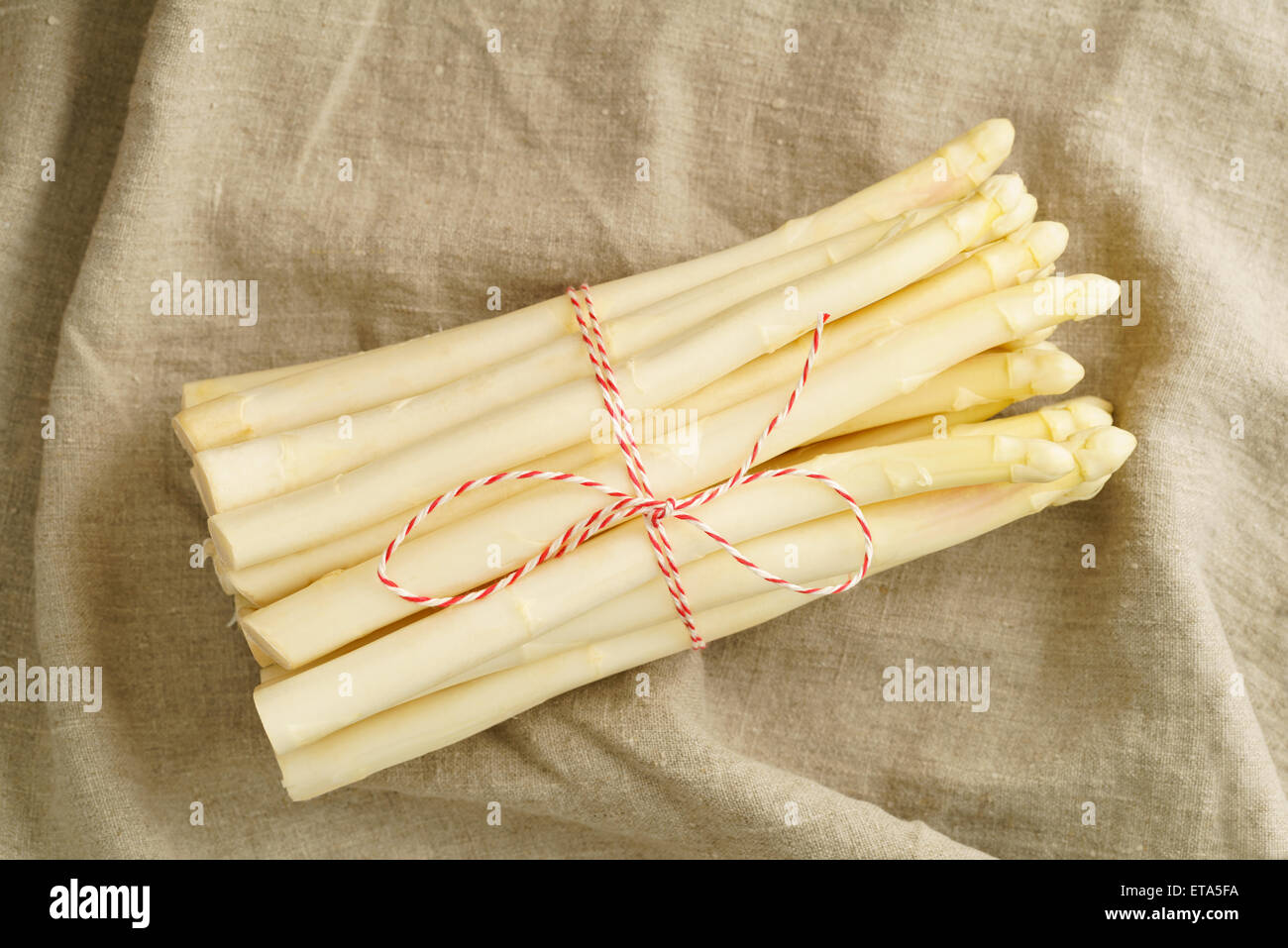 Bunch of fresh white asparagus on wooden table with linen cloth Stock Photo
