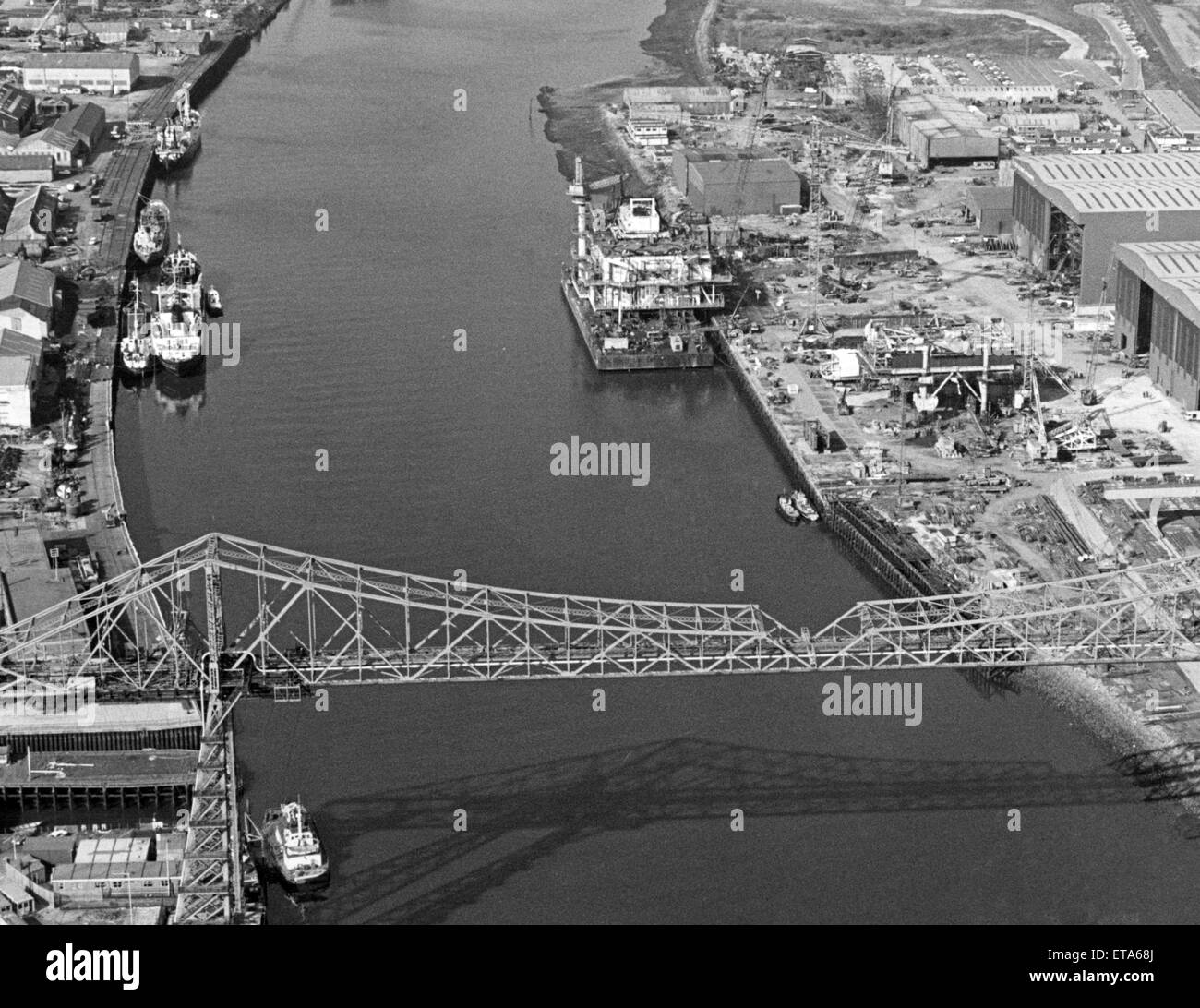 Aerial view of the biggest ever oil rig module to be made in Britain, as it waits to be towed under the Tees Transporter Bridge, on its way from Cleveland Offshore, Port Clarence to the Beatrice oil field off Scotland, 27th September 1983. Stock Photo