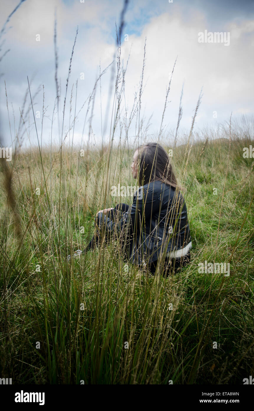Girl sitting alone in field hi-res stock photography and images - Alamy
