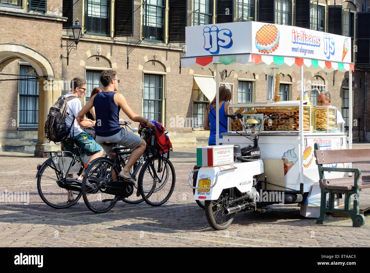 HAGUE, NETHERLANDS-AUGUST 01, 2014: Seller of ice-cream is ready to meet first customers in Binnenhof historical part of Hague Stock Photo
