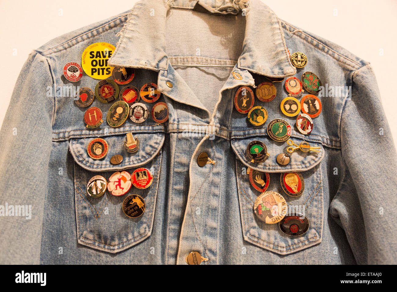 London, UK. 8 June 2015. Pictured: a jeans jacket with memorabilia badges. The Battle of Orgreave Archive (An Injury to One is an Injury to All) (2001), by Jeremy Deller. Press preview of the new Tate Britain exhibition 'Fighting History' which opens to the public on 9 June 2015 and will run until 13 September 2015. 'Fighting History' celebrates the enduring significance and emoptional power of British history painting from Ancient Rome to the Poll Tax Riots. Juxtaposing work from different periods, the exhibition explores how artists have reacted to historical events and how they capture and Stock Photo