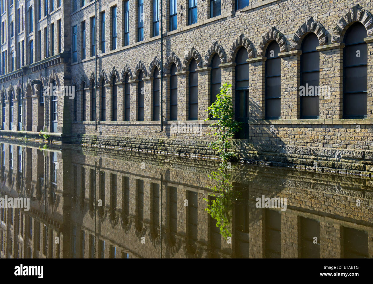 Salt's Mill, refl;ected in the Leeds and Liverpool Canal, Saltaire, West Yorkshire, England UK Stock Photo