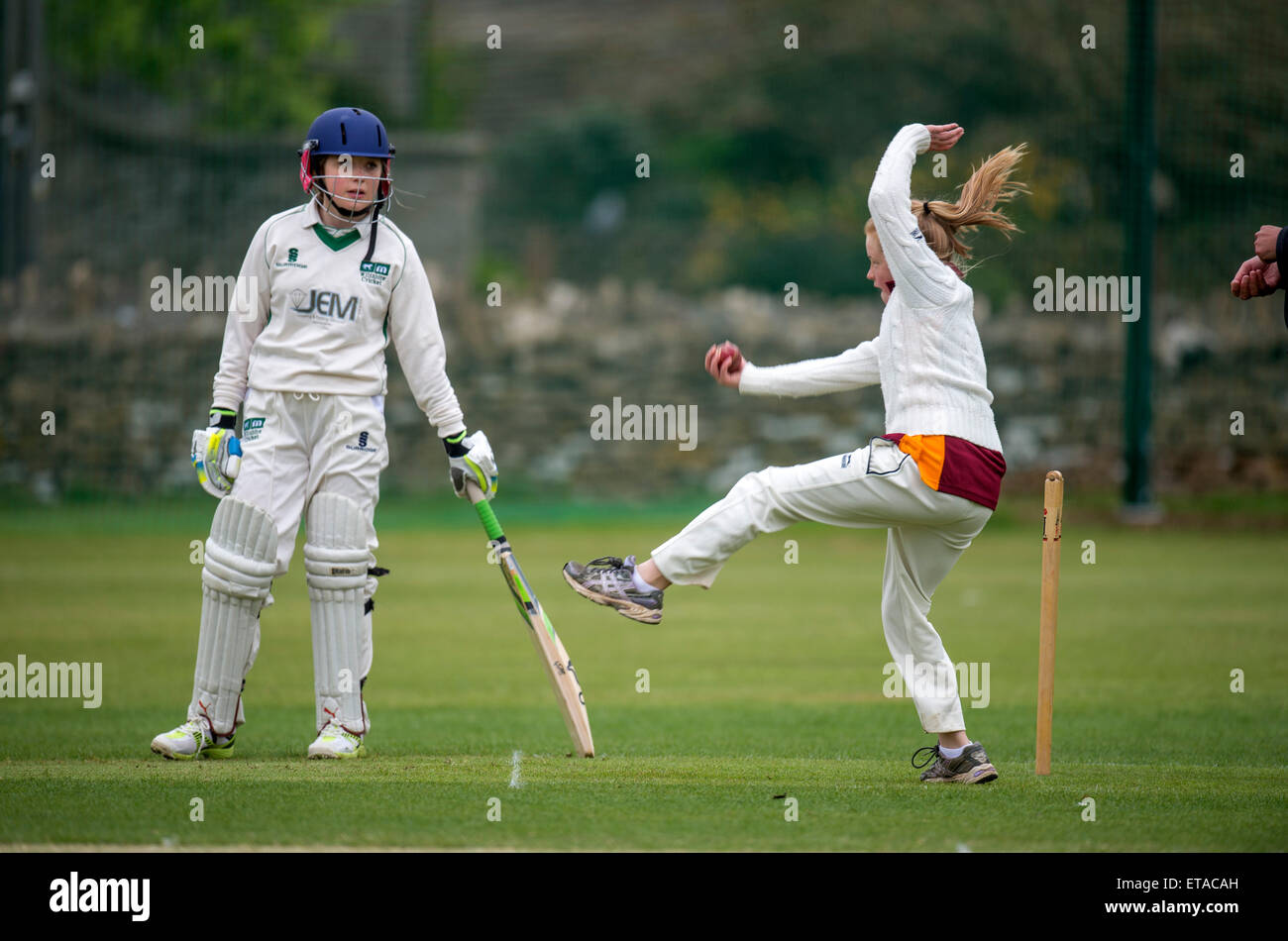 A bowler during a junior girls cricket match in Wiltshire UK Stock