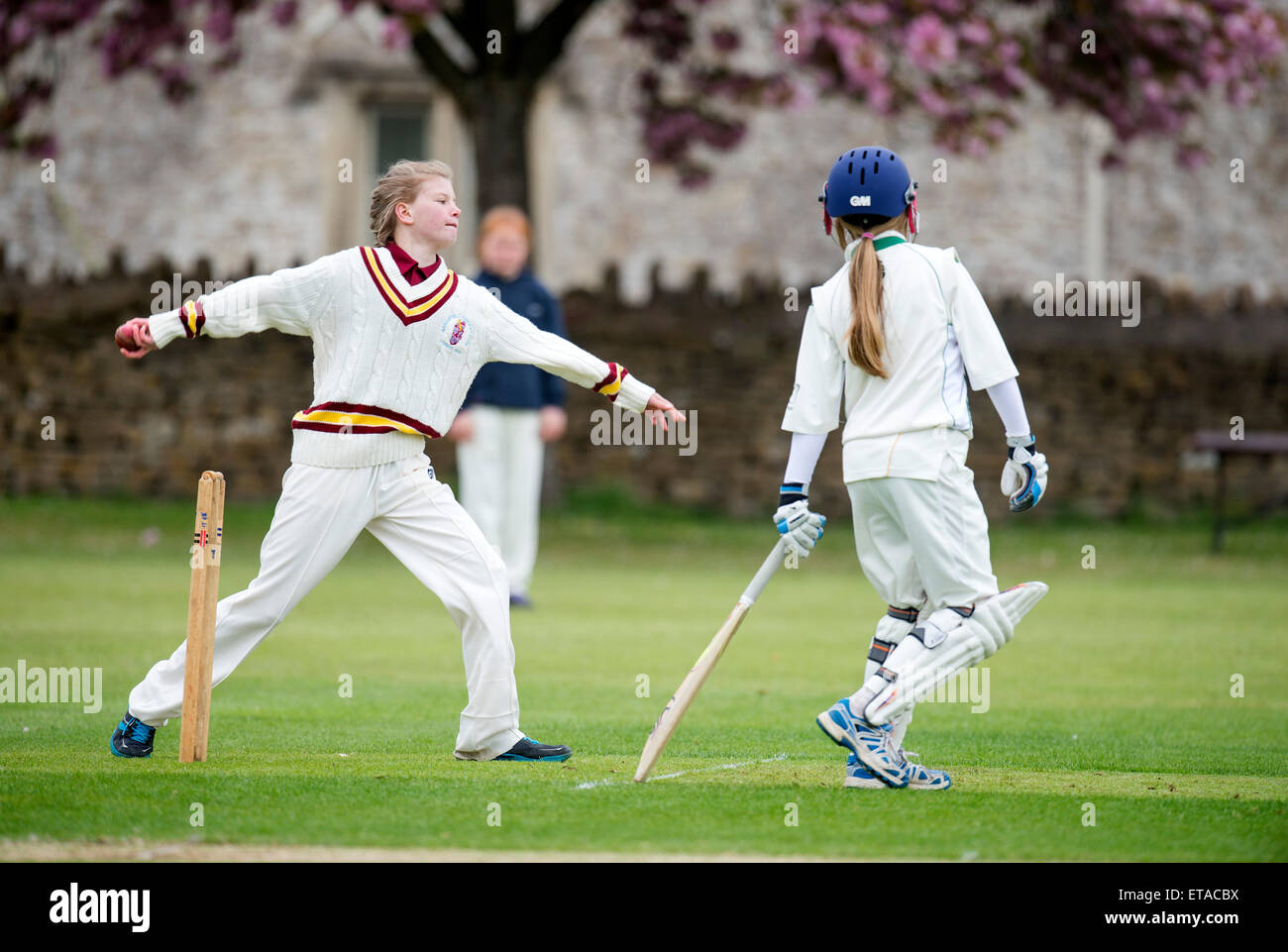 A bowler during a junior girls cricket match in Wiltshire UK Stock Photo