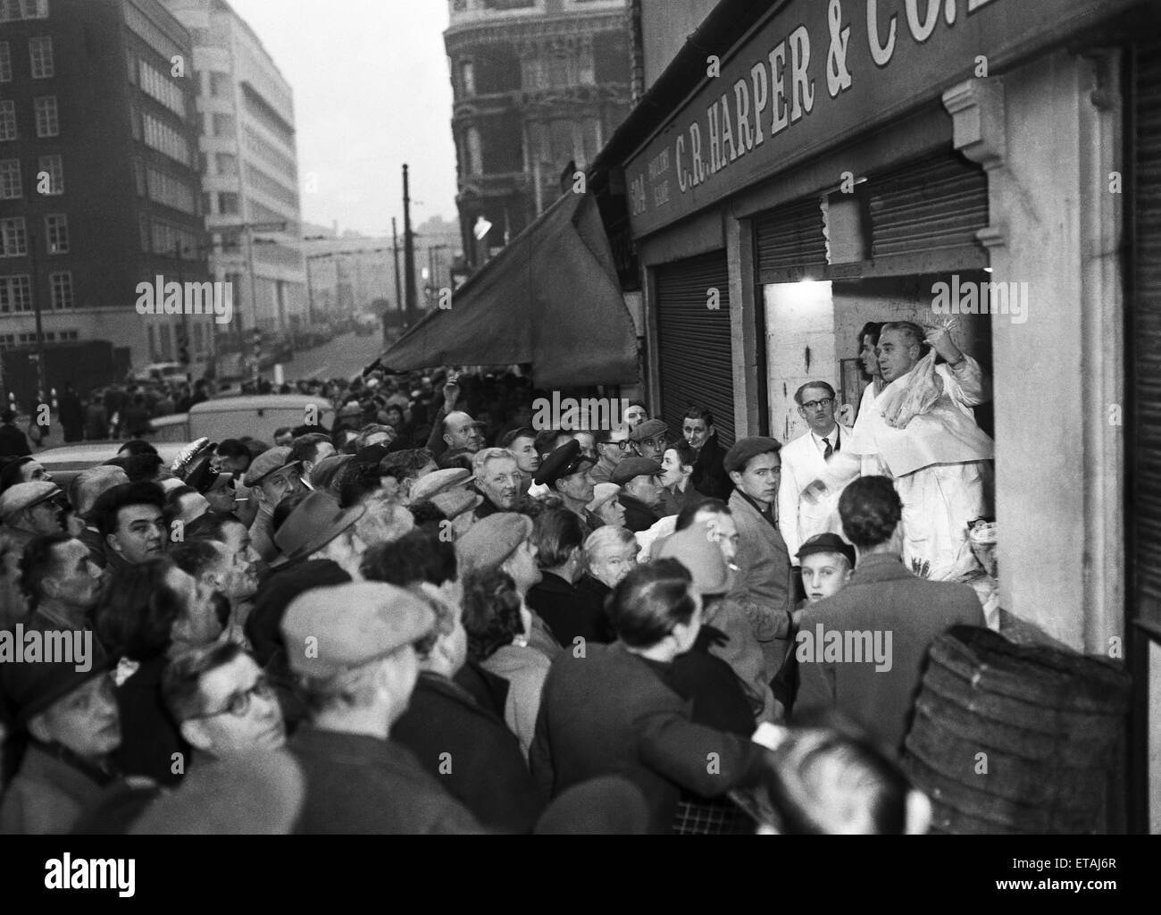 Shoppers looking for a last minute bargain gather around the poulterers stalls in Charterhouse Street close to Smithfield Market as the turkey auctions begin on Christmas Eve, London. Circa December 24th 1953 Stock Photo