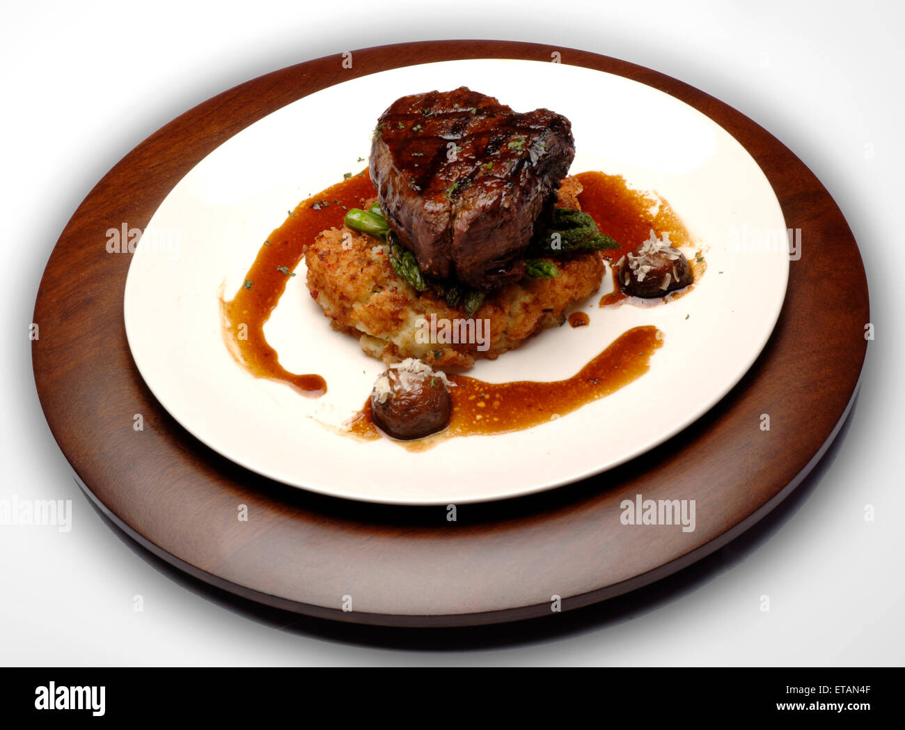 A beef entree on a bed of hashbrowns, garnished with asparagus and