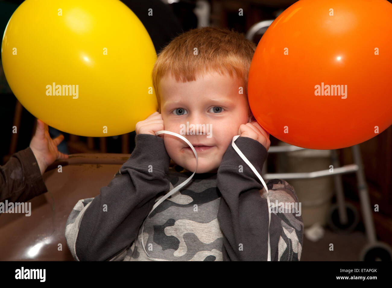 Boy age four celebrating with balloons at a birthday party. Battle Lake