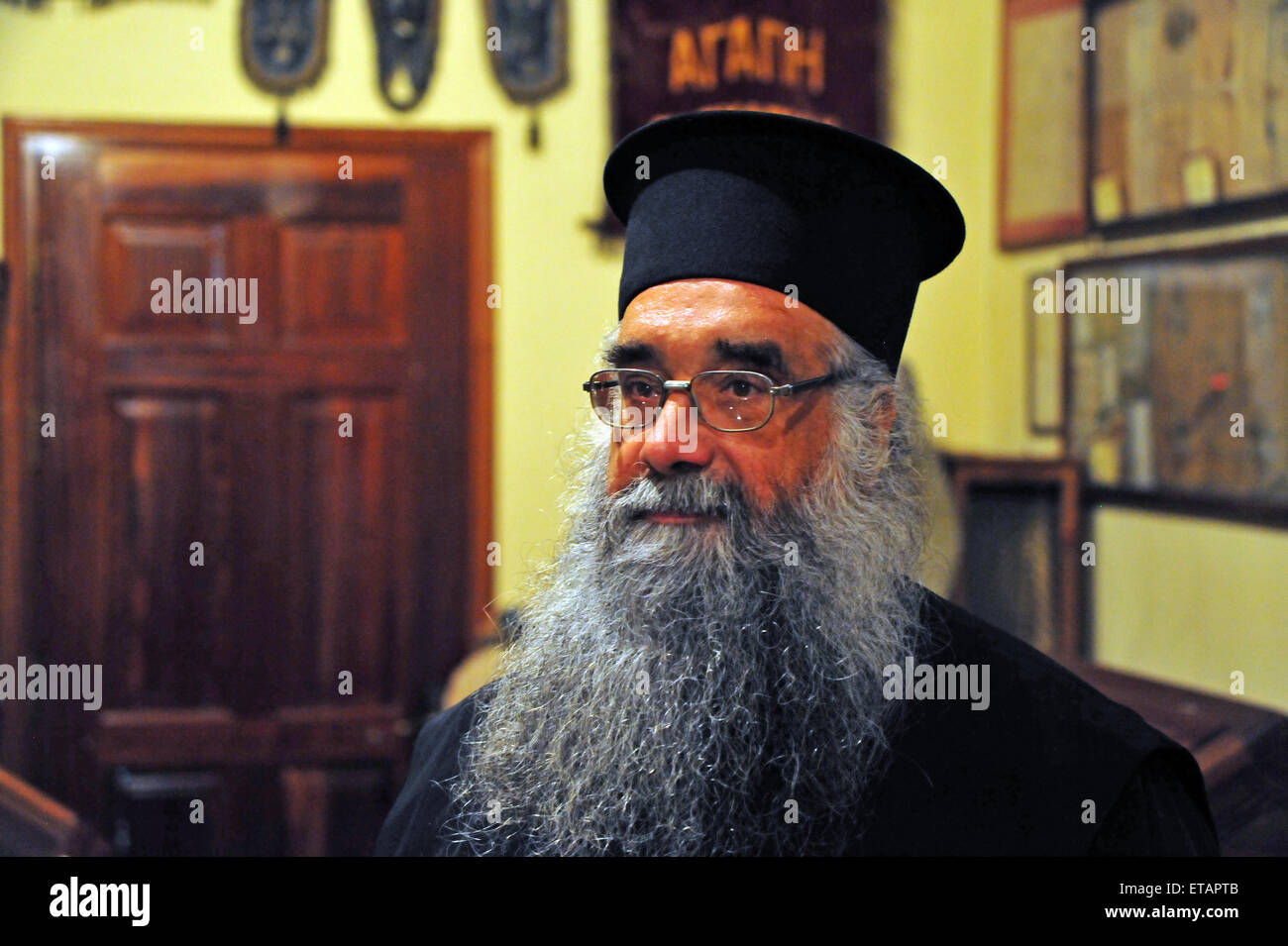 Greek-Orthodox priest in his church in Plomari, Lesvos. Due to the crisis he is very busy to comfort people. Editorial use only. Stock Photo