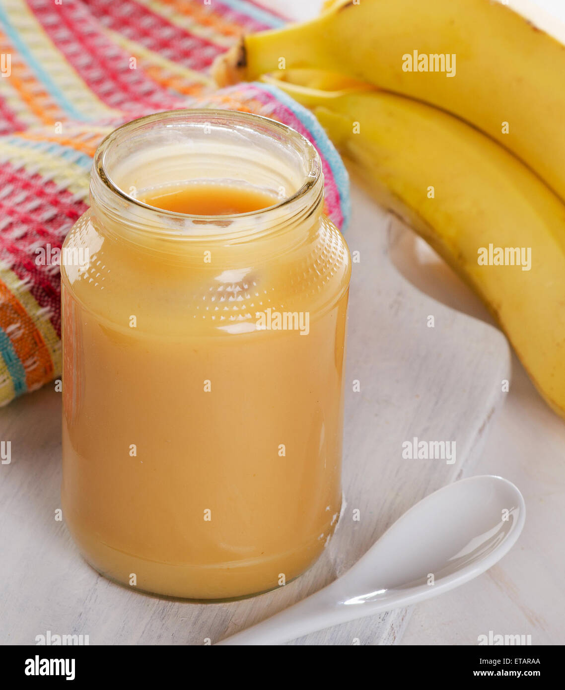 Baby puree in a glass jar with bananas. Selective focus Stock Photo