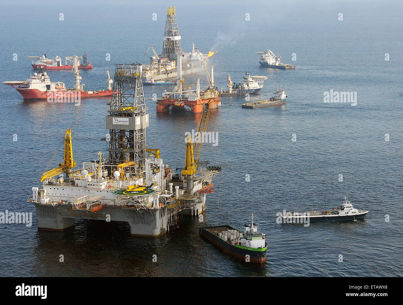 The mobile offshore drilling unit Development Driller II is prepares to drill a relief well at the BP Deepwater Horizon oil spill disaster site June 12, 2010 in the Gulf of Mexico. The drillship Discover Enterprise continues to capture oil and burn off gases from the ruptured riser in the background. Stock Photo