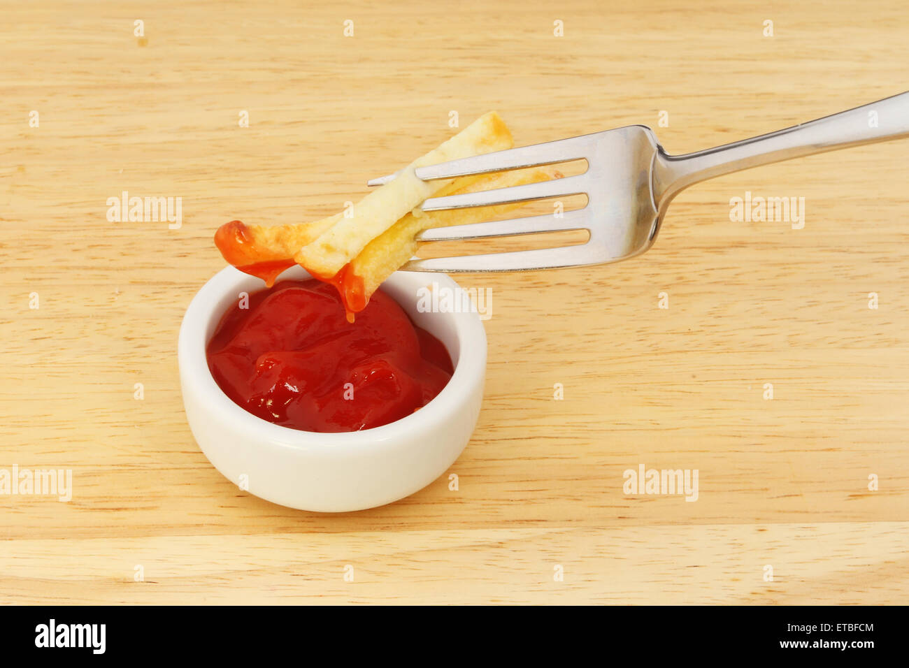 French fries on a fork dipping in tomato ketchup Stock Photo Alamy