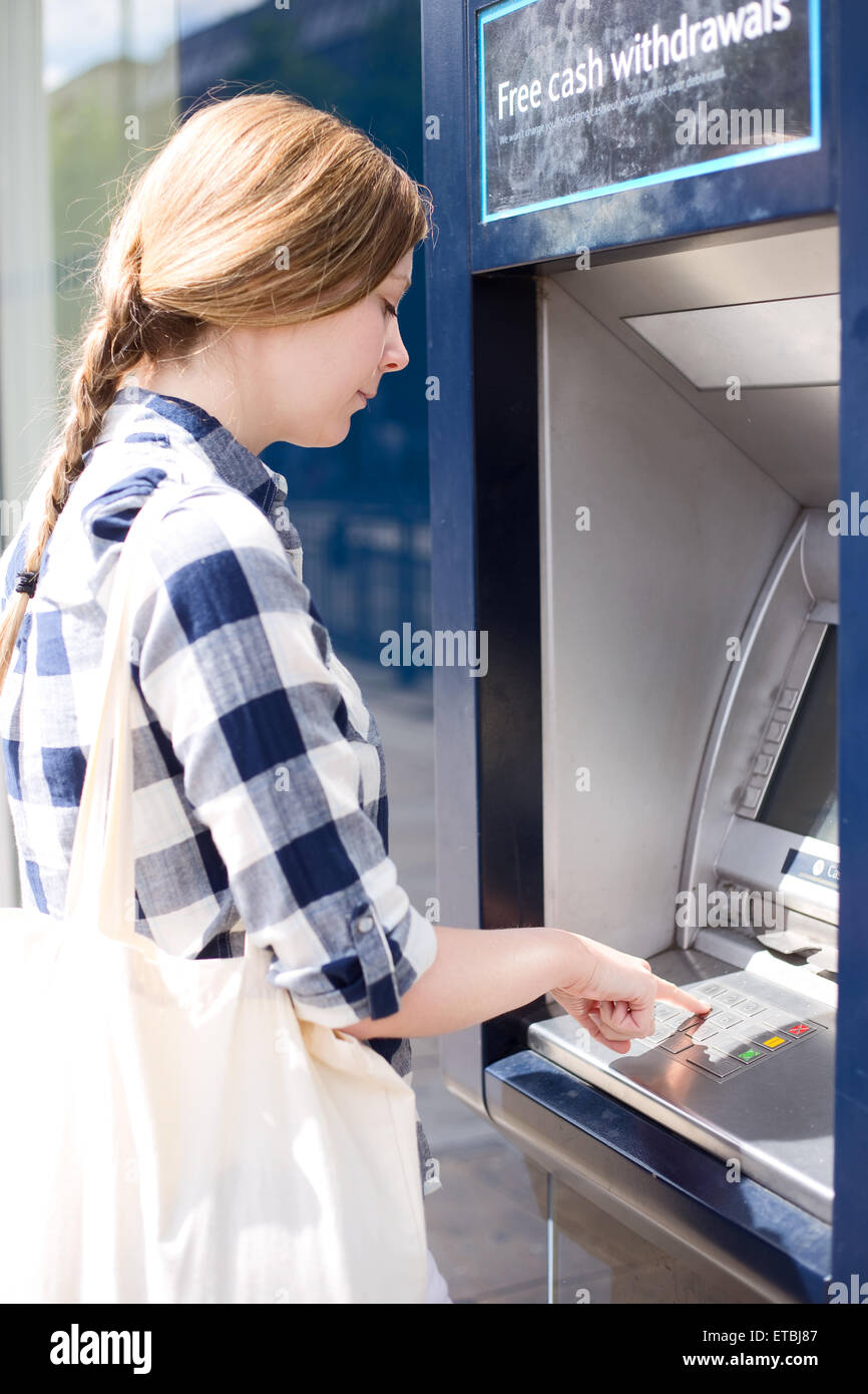 woman at the cash machine putting her pin in. Stock Photo