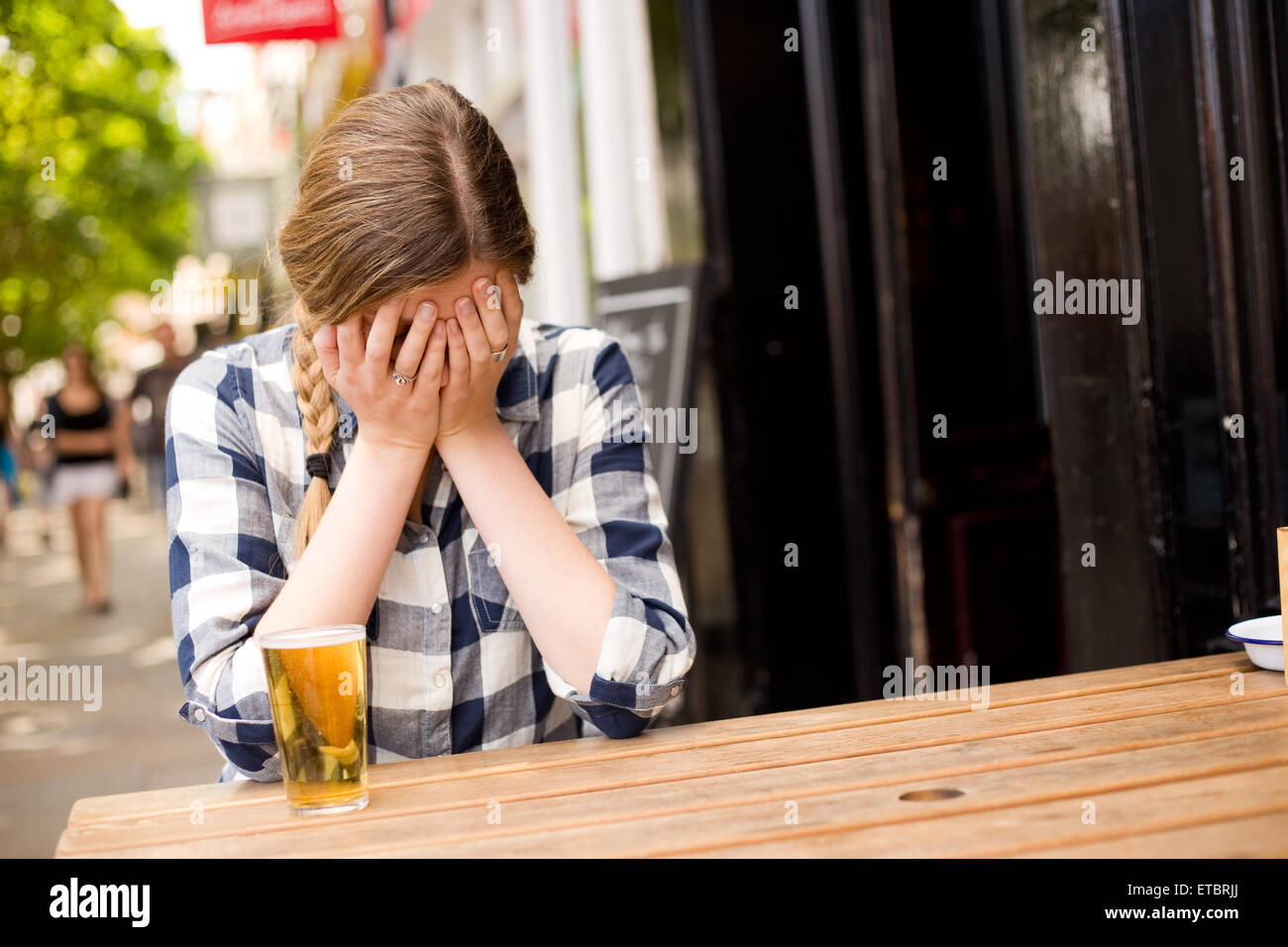 young woman upset at the pub crying Stock Photo
