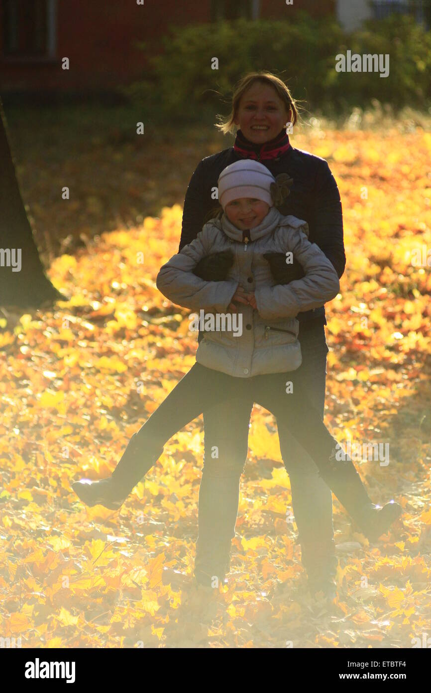 woman with her daughter playing about in the Autumn park Stock Photo