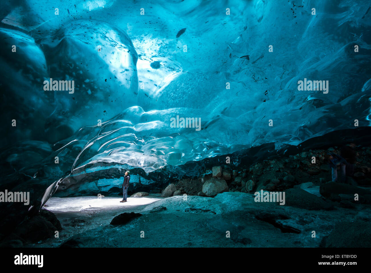 A man gazes up from an ice cave within the Mendenhall glacier, Southeast Alaska Stock Photo