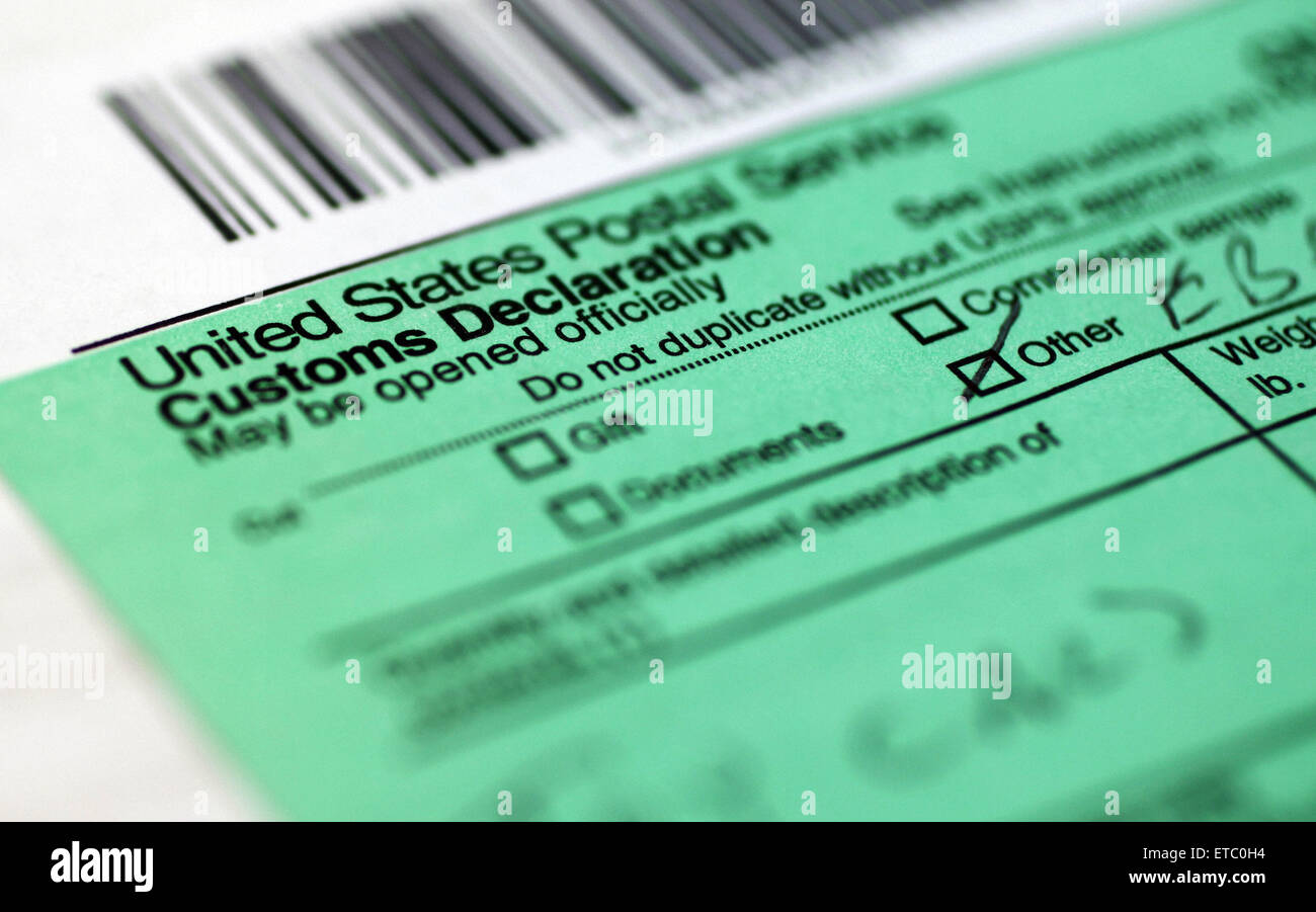 shipping mail package box with the U.S POST OFFICE Sticker label in main Focus showing the Customs Declaration form filled. Stock Photo