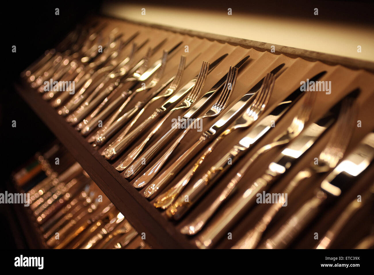 luxury set of silverware cutleries arranged in a fancy fine dining restaurant in golden color Stock Photo