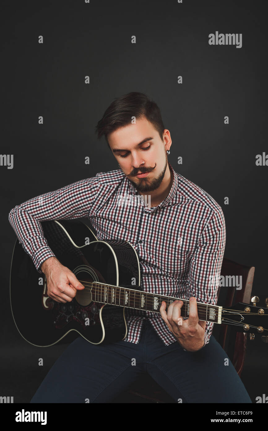 handsome guy with beard holding acoustic guitar Stock Photo