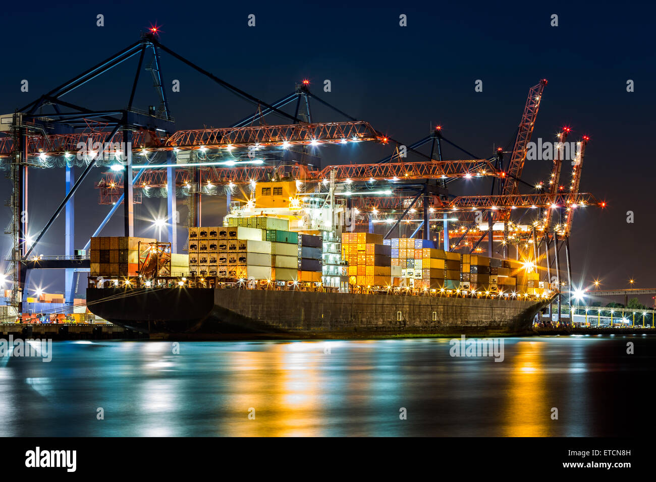 Cargo ship loaded in New York container terminal at night viewed from Elizabeth NJ across Elizabethport reach. Stock Photo