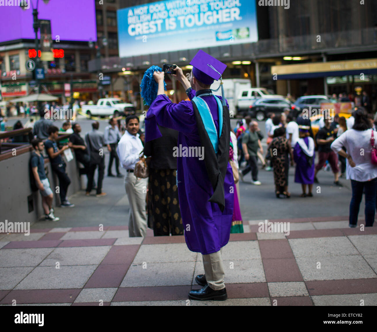 A graduate of Hunter College takes a 'selfie' photo wearing his cap and