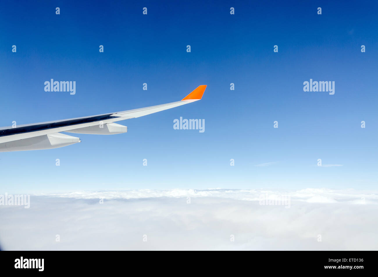 Plane wing, white clouds and blue sky Stock Photo