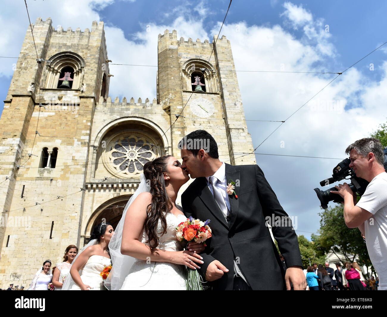 (150613) -- LISBON, June 13, 2015 (Xinhua) -- A couple of newly-weds kiss during a group wedding in Lisbon, Portugal, on June 12, 2015. A total of 11 couples married during a group wedding at Lisbon city cathedral Friday. (Xinhua/Zhang Liyun) (zhf) Stock Photo