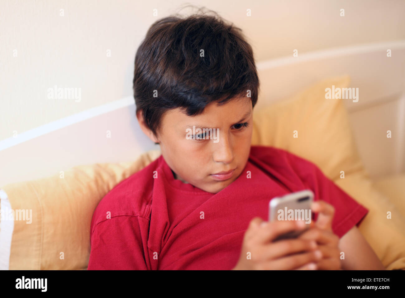 Young boy making selfie pictures with smart phone - with shallow depth of field Stock Photo