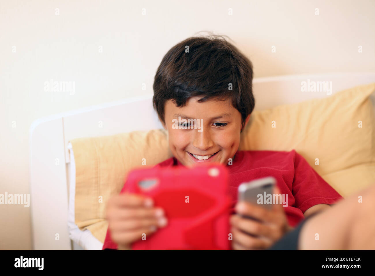 Young boy making selfie pictures with tablet and phone - with shallow depth of field Stock Photo