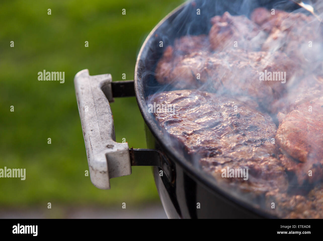 Meat on the Barbeque smoking. Stock Photo