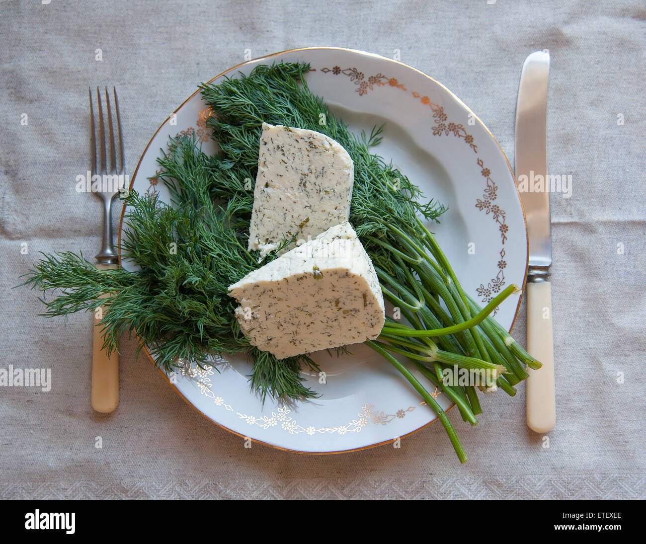 kozeva piece of cheese on a plate with greens Stock Photo