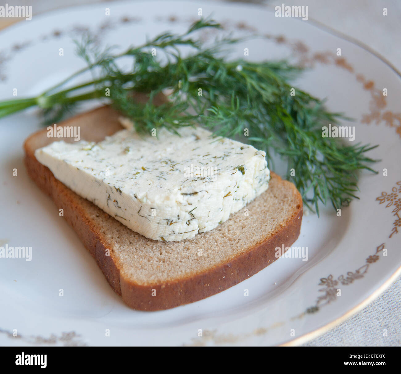 kozeva piece of cheese on a plate with greens Stock Photo