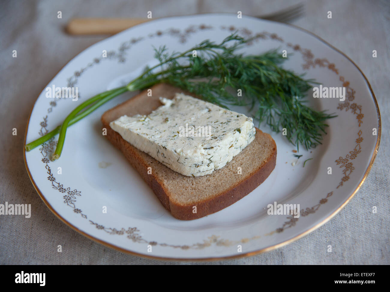 kozeva piece of cheese on a plate with greens Stock Photo