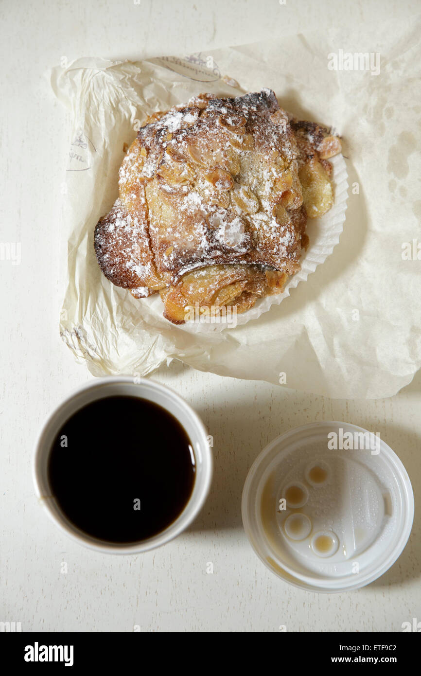 French Chocolate Croissant And A Paper Cup Of Coffee On White Table French Chocolate Croissant And A Paper Cup Of Coffee On White Table
