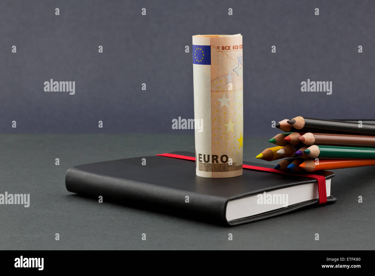 Business opportunities and challenges for the euro reflected in multiple colors of pencils, Euro currency, and black journal Stock Photo