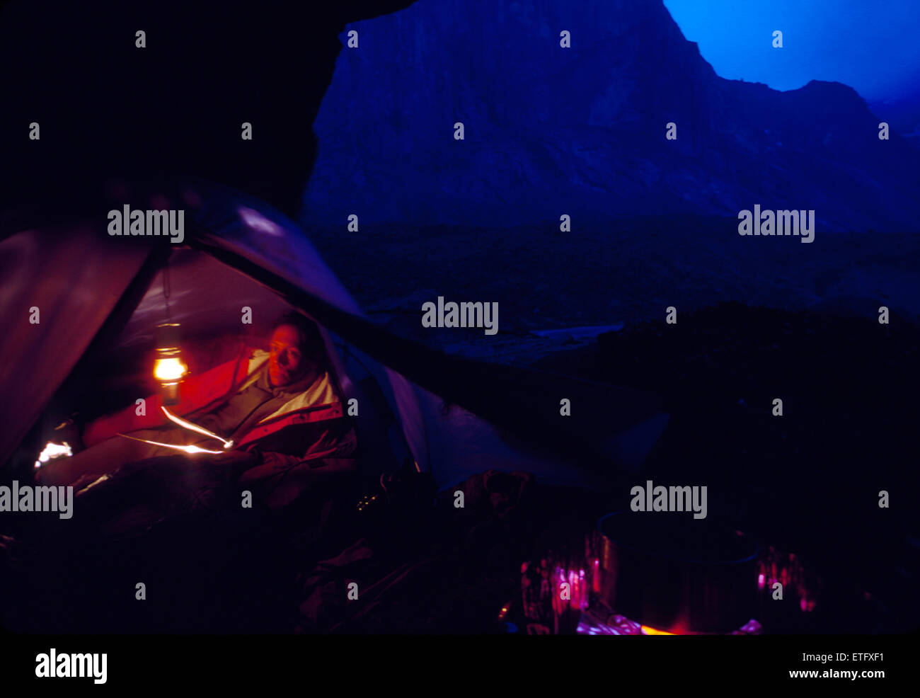 Night view of male backpacker camped in tent, Auyuittuq National Park, Baffin Island, Nunavut, Canada Stock Photo